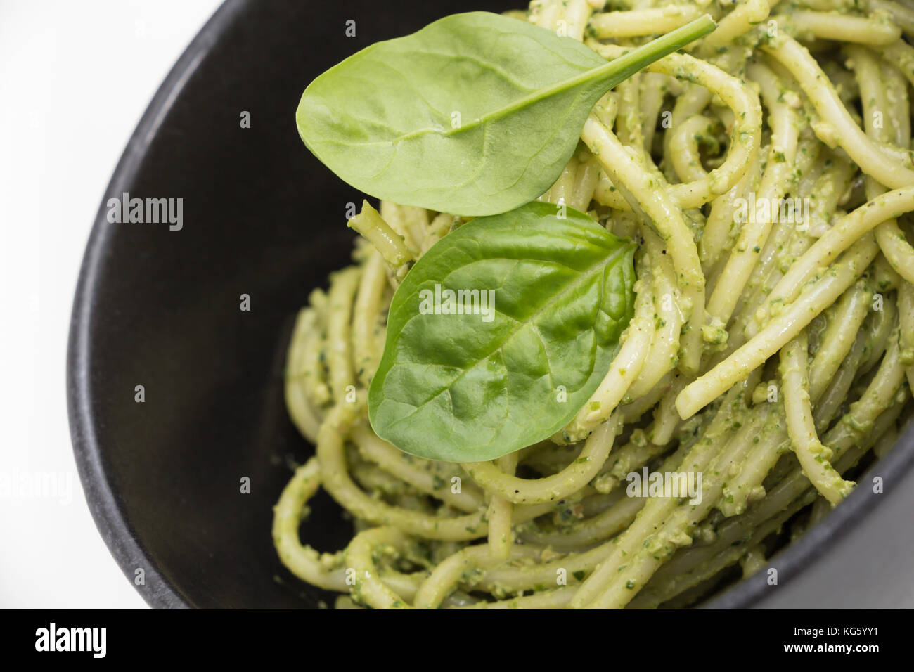 Les pâtes spaghetti avec sauce pesto dans le bol noir, gros plan arrière-plan. Banque D'Images