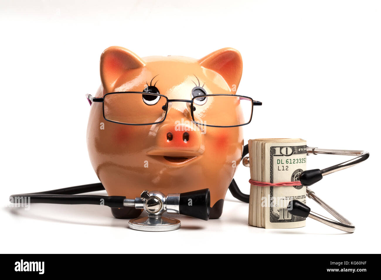 Cute tirelire avec stéthoscope noir et argent billets rouleau isolé sur fond blanc Banque D'Images