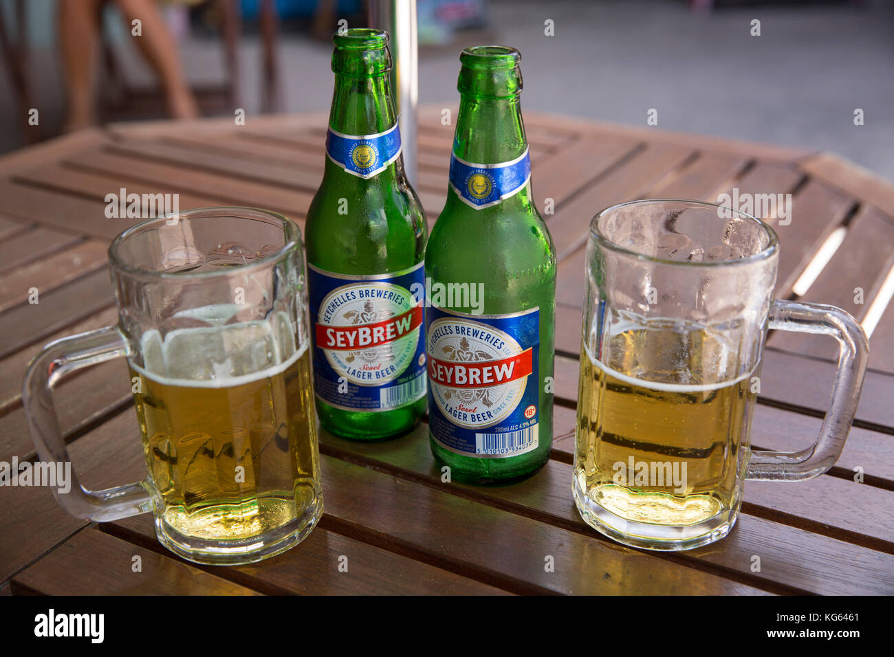 Les Seychelles, Praslin, Baie St Anne, bouteilles et verres de bière Seybrew sur table restaurant à emporter Banque D'Images
