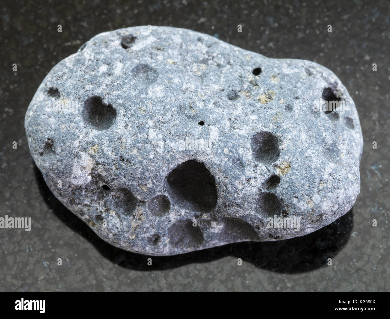 La prise de vue macro des eaux minérales naturelles rock specimen - gris de galets de pierre ponce sur fond de granit sombre de la Sicile Banque D'Images