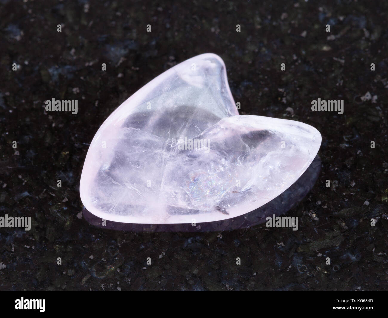 La prise de vue macro des eaux minérales naturelles rock specimen - tumbled pierre quartz rose en forme de coeur sur fond de granit sombre dans le Dakota du Sud, USA Banque D'Images