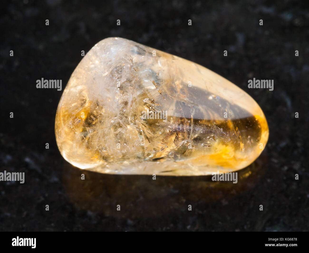 La prise de vue macro des eaux minérales naturelles rock specimen - pierre citrine polie sur fond de granit sombre Banque D'Images