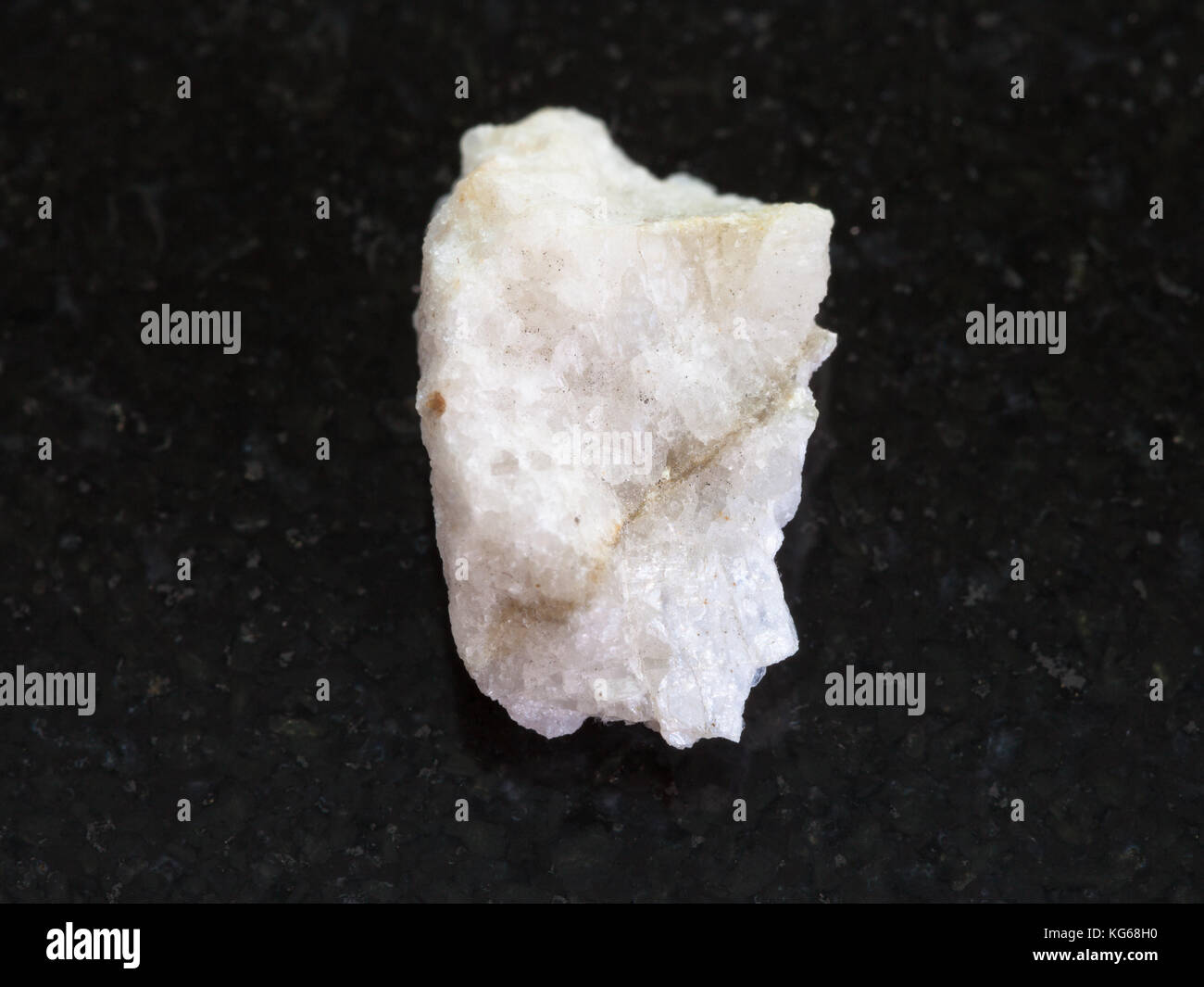 La prise de vue macro des eaux minérales naturelles rock specimen - la scheelite (veine) de minerai de tungstène en pierre brute sur fond de granit sombre Banque D'Images