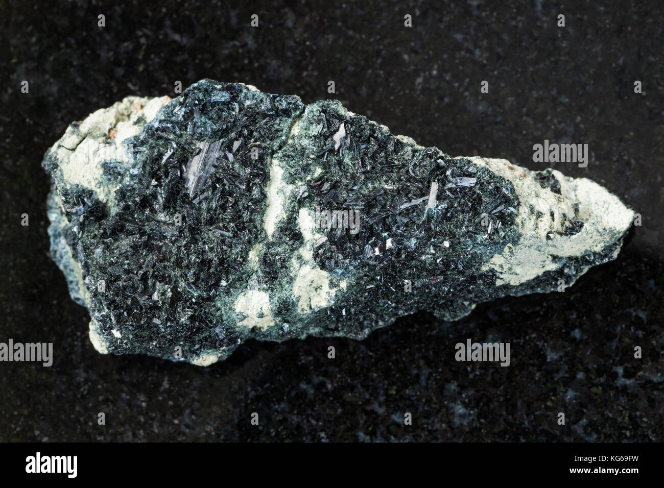 La prise de vue macro de pierre minérale naturelle - Spécimen de cristal rugueux - amphibole hornblende sur roches carbonatées sur fond de granit sombre korshunov Banque D'Images