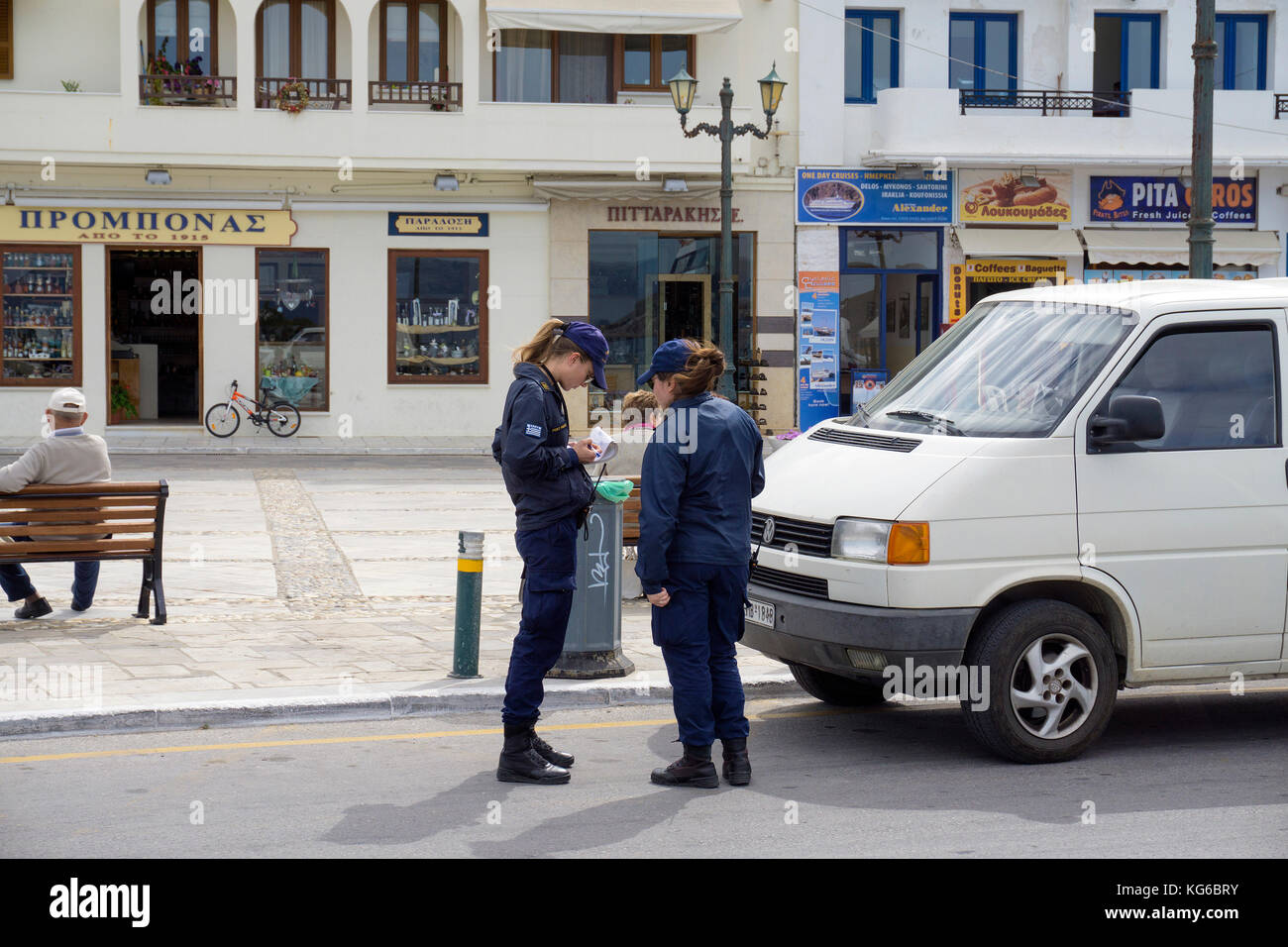 La police grecque écrit un billet pour une voiture à aucune attente, Naxos-ville, l'île de Naxos, Cyclades, Mer Égée, Grèce Banque D'Images