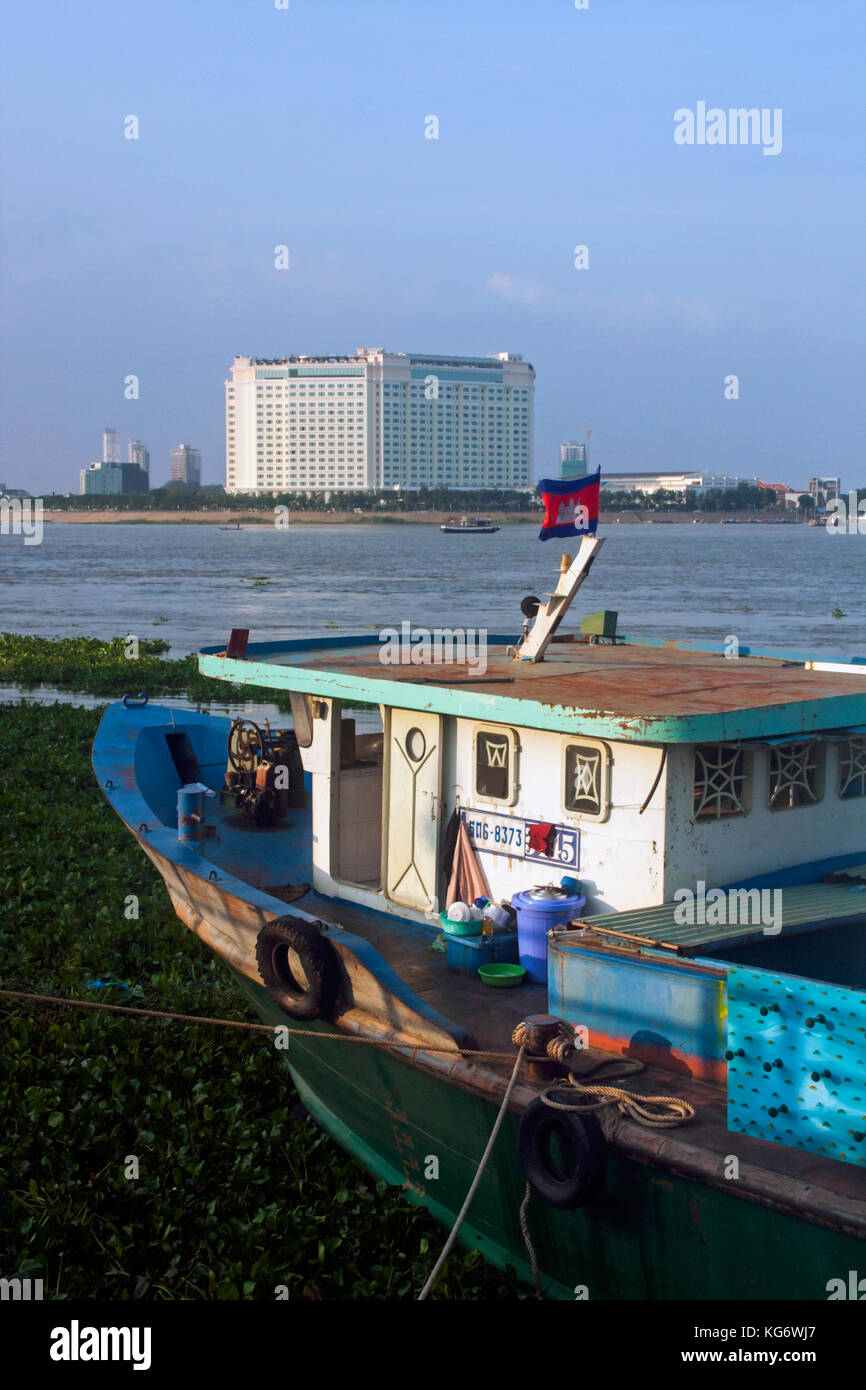 Une ancienne péniche rustique est amarré à la rive du Mékong, en face de la nouvelle sokha hotel à Phnom Penh, Cambodge. Banque D'Images