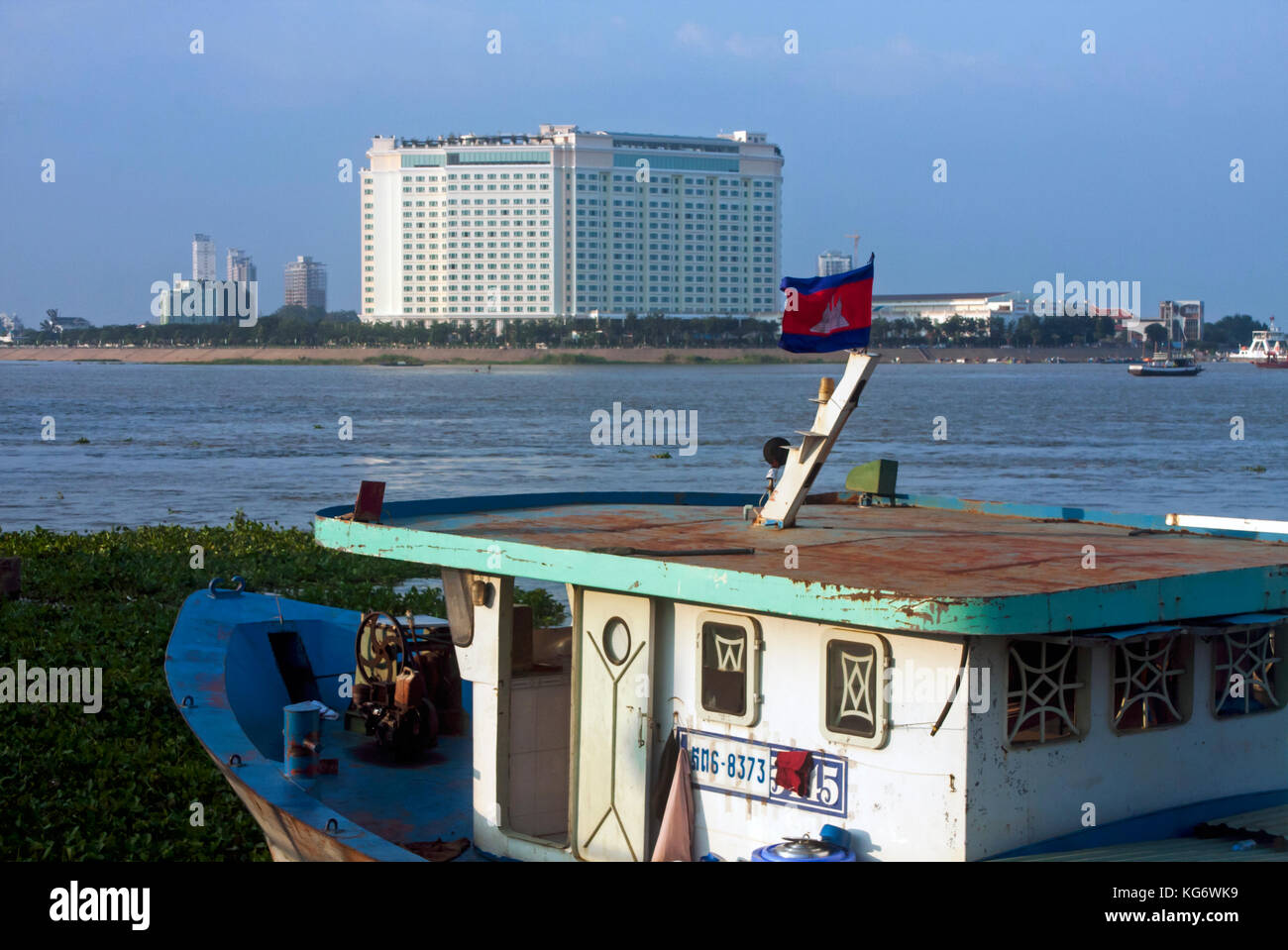 Une ancienne péniche rustique est amarré à la rive du Mékong, en face de la nouvelle sokha hotel à Phnom Penh, Cambodge. Banque D'Images