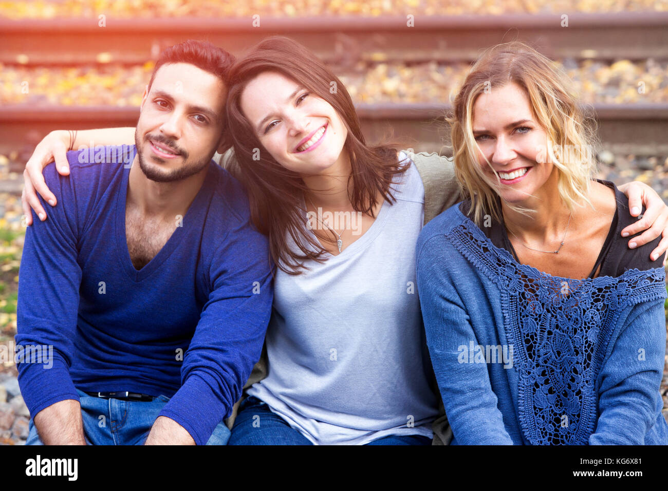 Portrait de trois amis assis sur les voies ferrées et profiter du soleil Banque D'Images