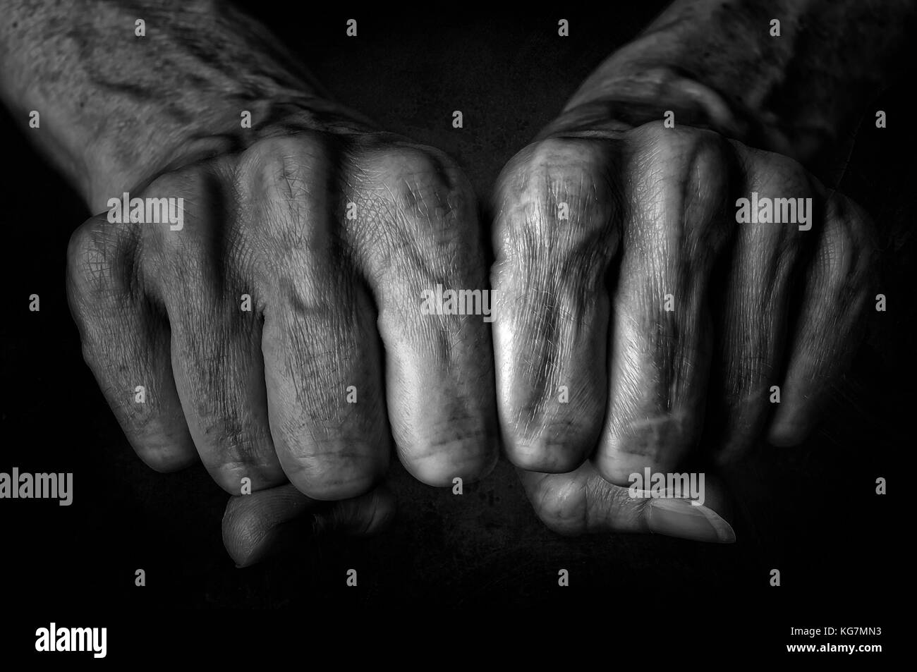 Photo en noir et blanc des hauts femme poings sur fond noir Banque D'Images