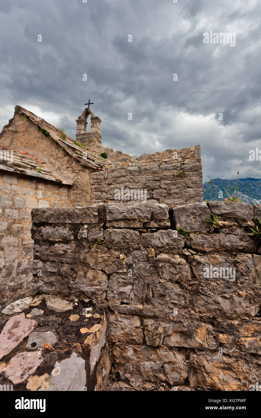 En vertu de l'ancienne église en pierre sombre ciel avec nuages. Monténégro Banque D'Images