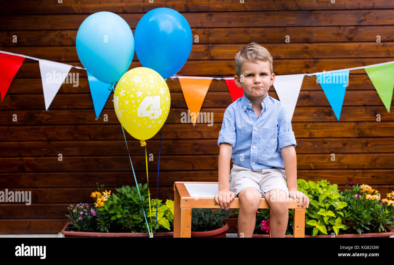 Portrait of young boy sitting on table at Birthday party Banque D'Images