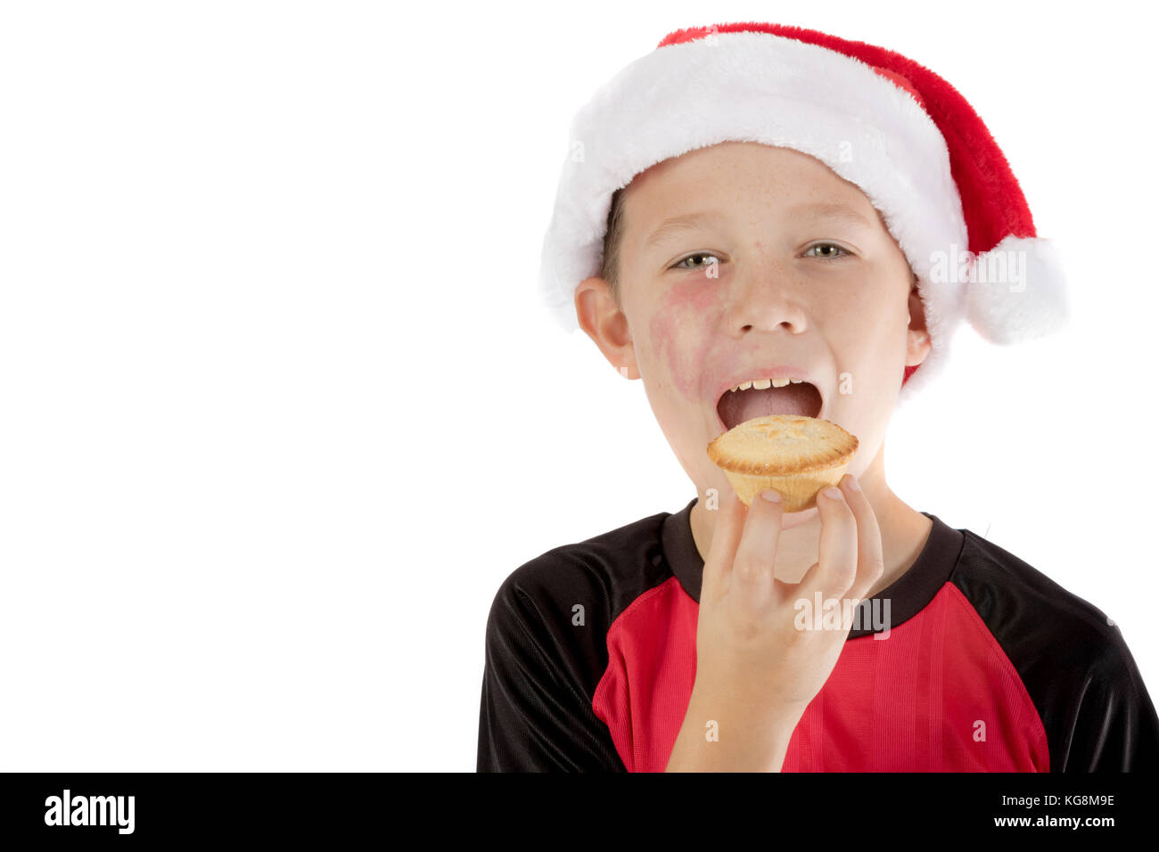 Pre-teen boy in christmas hat et un mince pie Banque D'Images