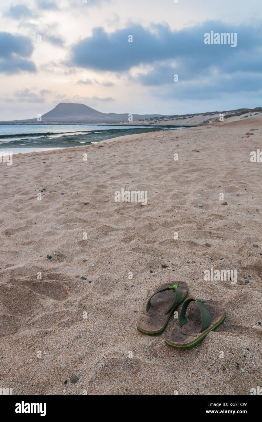 Vue sur Playa del Salado avec sandales au premier plan, La Graciosa, îles de Canaries, Espagne Banque D'Images