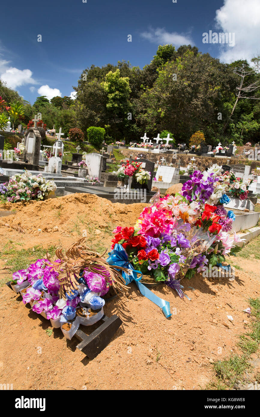 Les Seychelles, La Digue, l'île d'Anse sévère, cimetière, fleurs artificielles sur creusé récemment de graves Banque D'Images