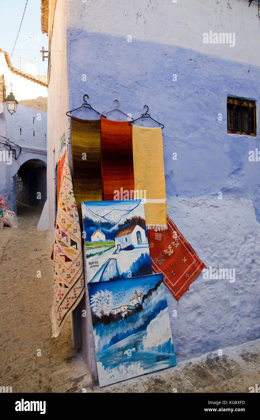 Affiche des tapis et des peintures dans Chefchaouen, Maroc Banque D'Images