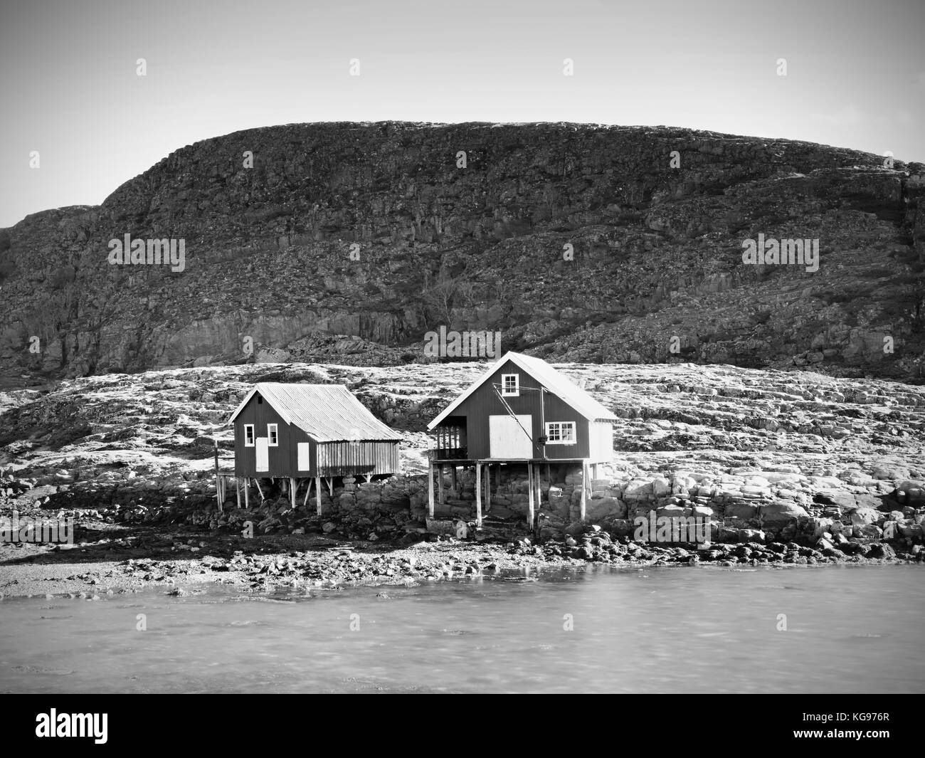 Maison de bateau rouge au quai, l'île rocky, en Norvège. rouge traditionnel au bâtiment blanc, jetée en bois près de la mer froide. dark rocky Hill dans l'arrière-plan. Banque D'Images