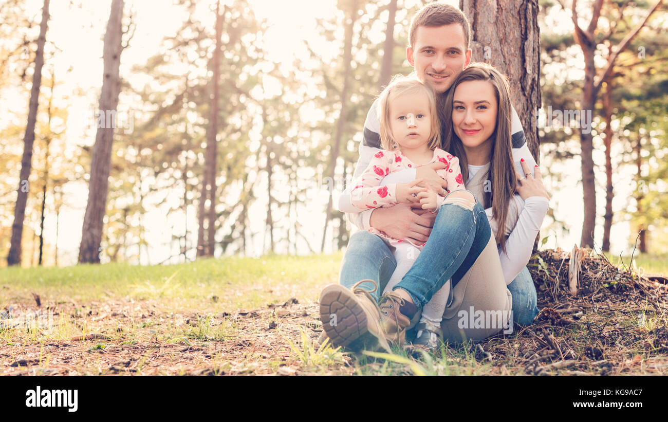 Jeune famille de trois s'amusant dans un parc, profiter de leur temps ensemble. real people, real, l'authenticité de la famille concept Banque D'Images