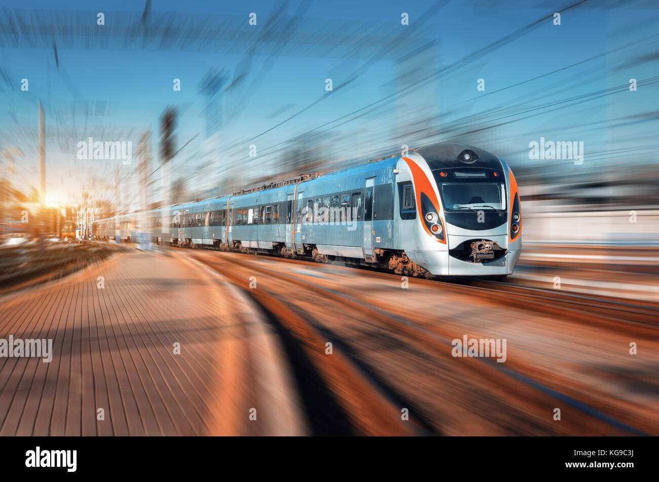 High speed train arrive sur la gare au coucher du soleil. moderne train intercity en mouvement sur le quai de la gare. train de voyageurs le fer avec Banque D'Images