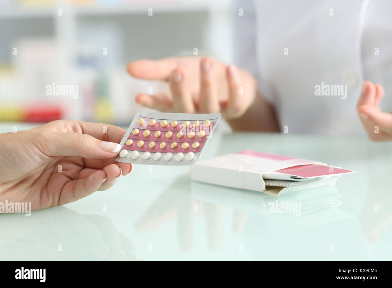 Close up of a Girl mains acheter pilules contraceptives et pharmacien expliquant dans une pharmacie Banque D'Images