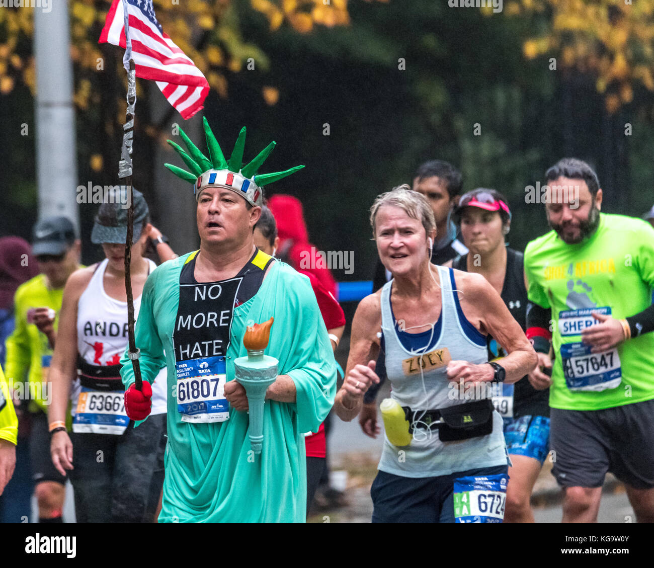 New York, États-Unis. 5 novembre 2017. Un coureur portant un costume de la Statue de la liberté et portant un drapeau américain et une indication « plus de haine » traverse la Cinquième Avenue pendant le marathon de New York. Crédit: Enrique Shore/Alay Live News Banque D'Images