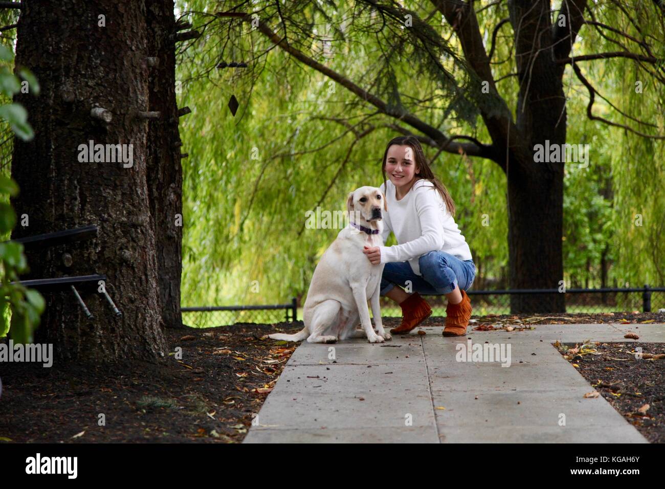 Portrait d'une jeune adolescente et son chien labrador en face d'un saule Banque D'Images