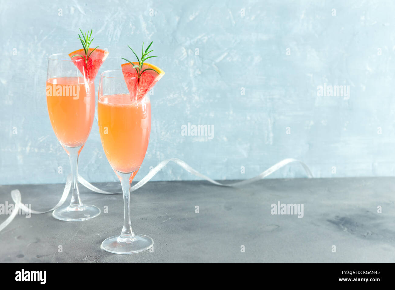 Boisson festive mimosa - cocktail au champagne mimosa avec du pamplemousse et romarin pour une fête de Noël, copy space Banque D'Images