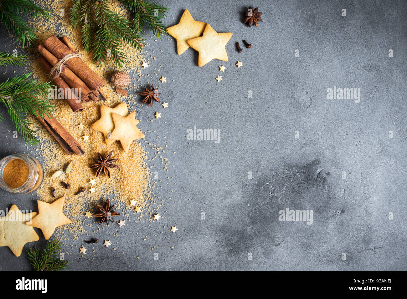 Épices de Noël, Christmas et ingrédients sur fond de béton gris. cannelle, anis étoile, muscade, cardamome, clou de girofle, le sucre brun Banque D'Images