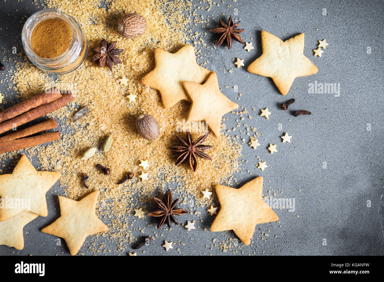 Épices de Noël, Christmas et ingrédients sur fond de béton gris. cannelle, anis étoile, muscade, cardamome, clou de girofle, le sucre brun Banque D'Images