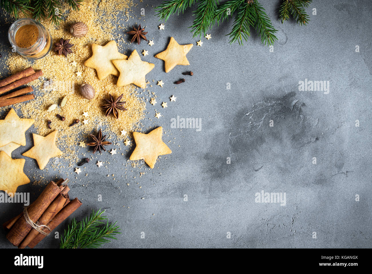 Épices de Noël, Christmas et ingrédients sur fond de béton gris. cannelle, anis étoile, muscade, cardamome, clou de girofle, le sucre brun Banque D'Images