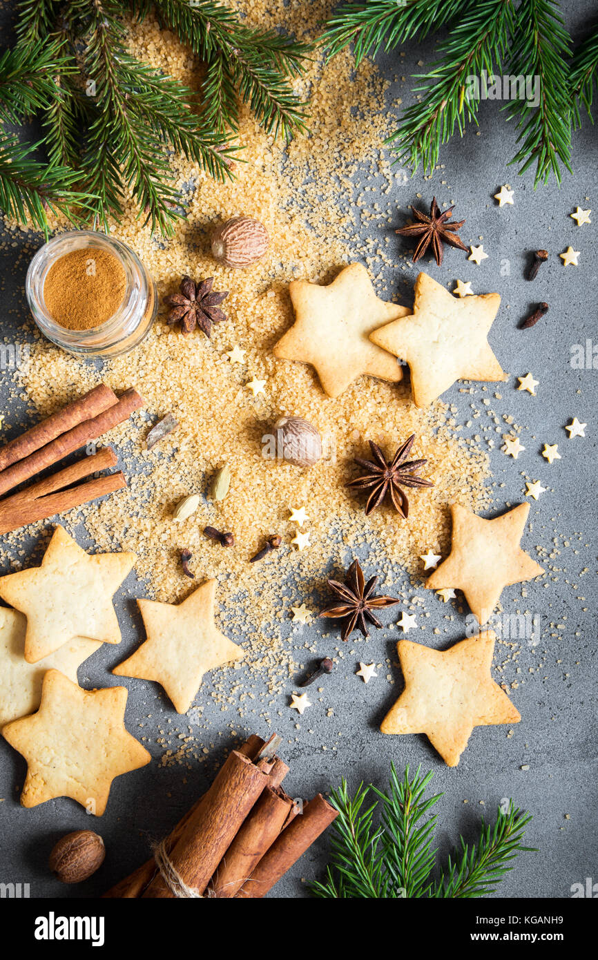 Épices de Noël, Christmas et ingrédients sur fond de béton gris. cannelle, anis étoile, muscade, cardamome, clou de girofle, le sucre brun Banque D'Images