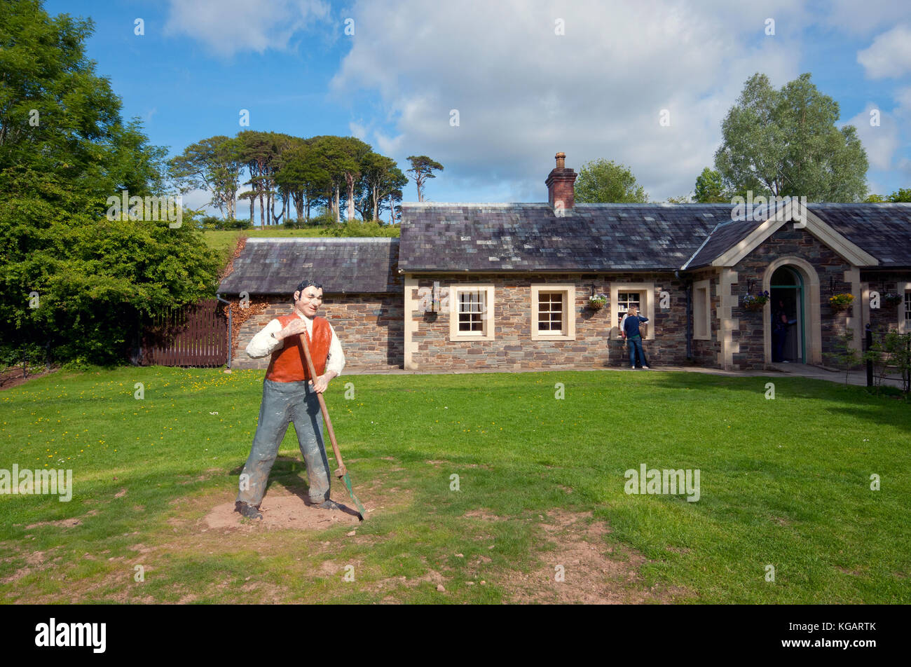 Statue de paysan sur l'herbe à l'entrée des fermes traditionnelles de Muckross, Muckross House and Gardens, le Parc National de Killarney, comté de Kerry, Irlande Banque D'Images