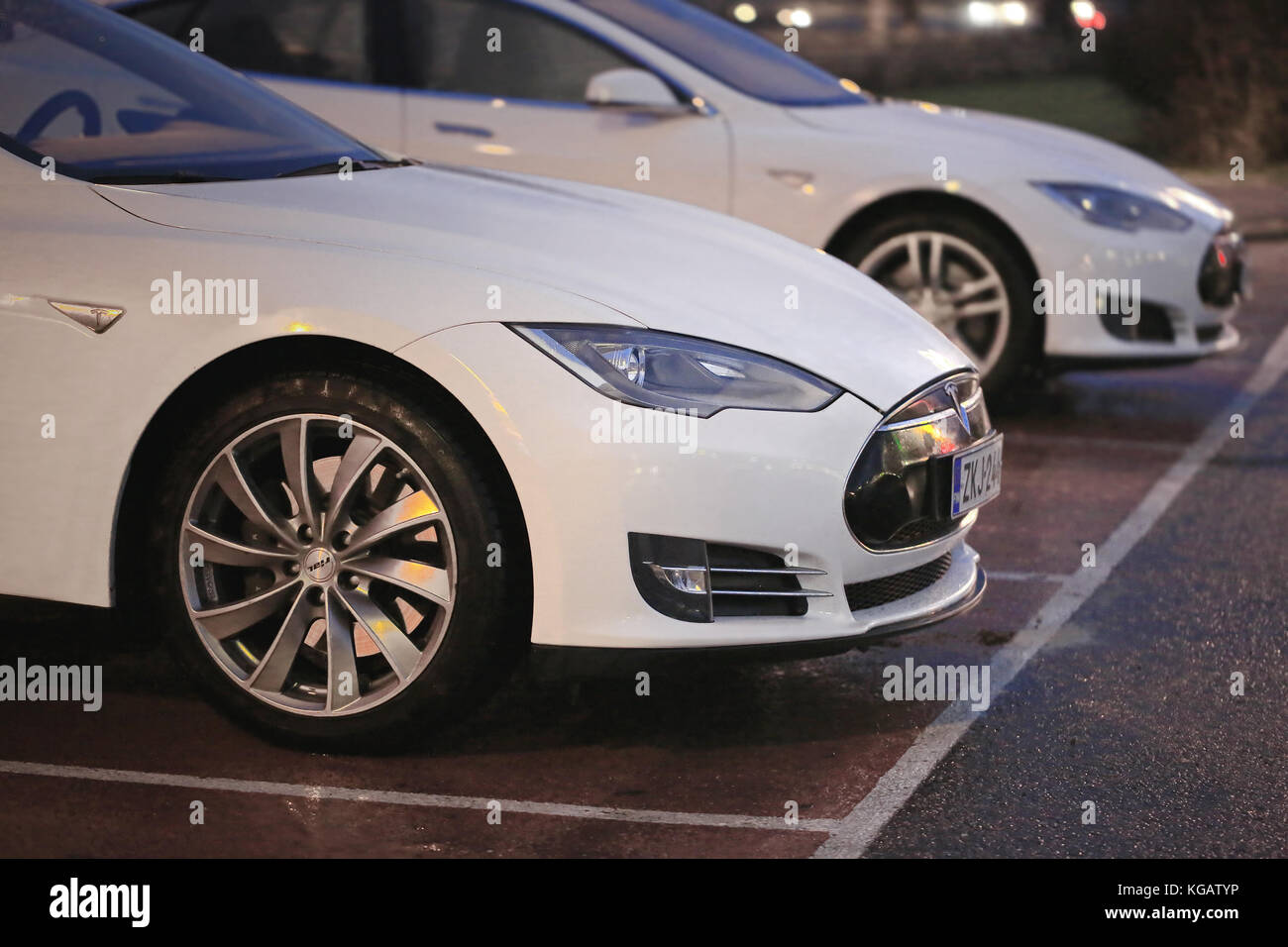 PAIMIO, FINLANDE - le 14 novembre 2015 : Tesla Model S blanc deux voitures sont facturés à Tesla Supercharger station à nuit. Suralimentation Tesla sont op Banque D'Images