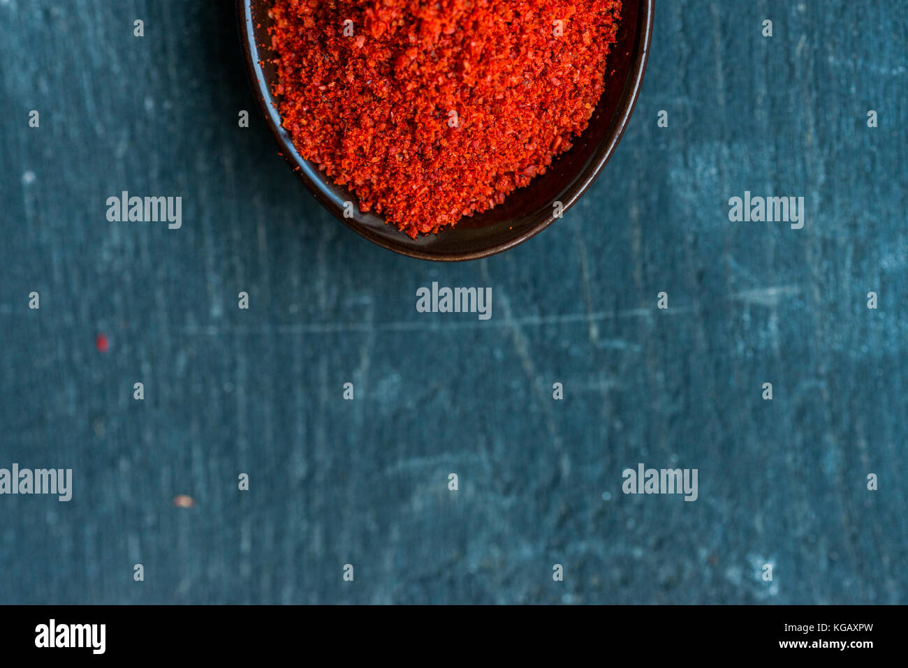 Close up spoon rempli d'épices paprika rouge foncé sur fond de bois Banque D'Images Close up spoon rempli d'épices paprika rouge foncé sur fond de bois Banque D'Images
