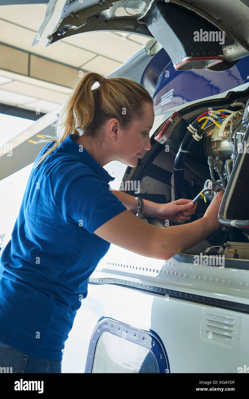 Aero femme ingénieur travaillant sur helicopter in hangar Banque D'Images