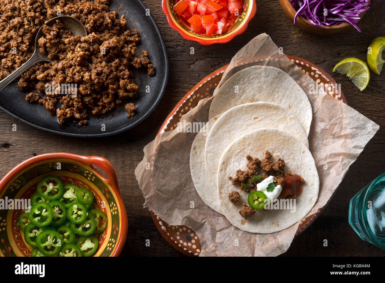 De délicieux tacos au boeuf au sol avec piment jalapeno, la salsa, la coriandre, la crème sure, et de la chaux. Banque D'Images
