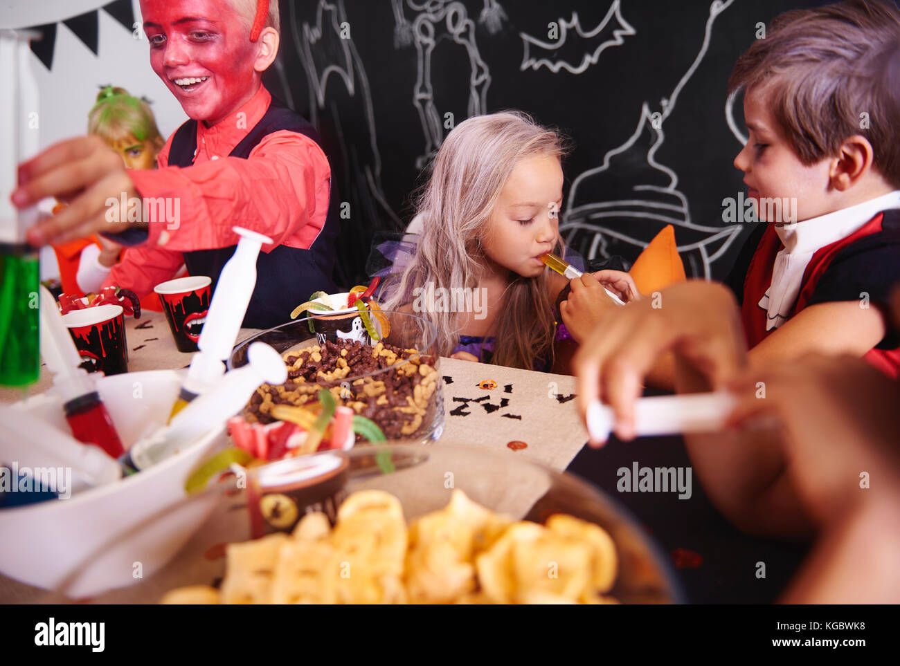 Les enfants partageant la nourriture à Halloween party Banque D'Images