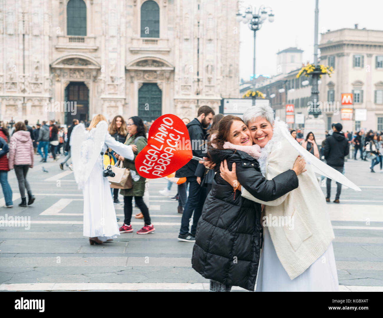 Des femmes habillées comme des anges donnant de la "free hugs" à des étrangers à la piazza Duomo de Milan Banque D'Images