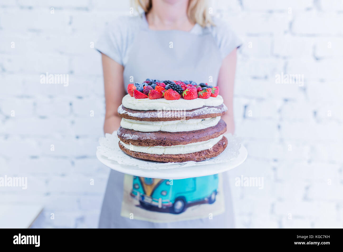 Whoopie chocolat gâteau sur la plaque avec les baies fraîches, women's hands holding. fond blanc. Banque D'Images