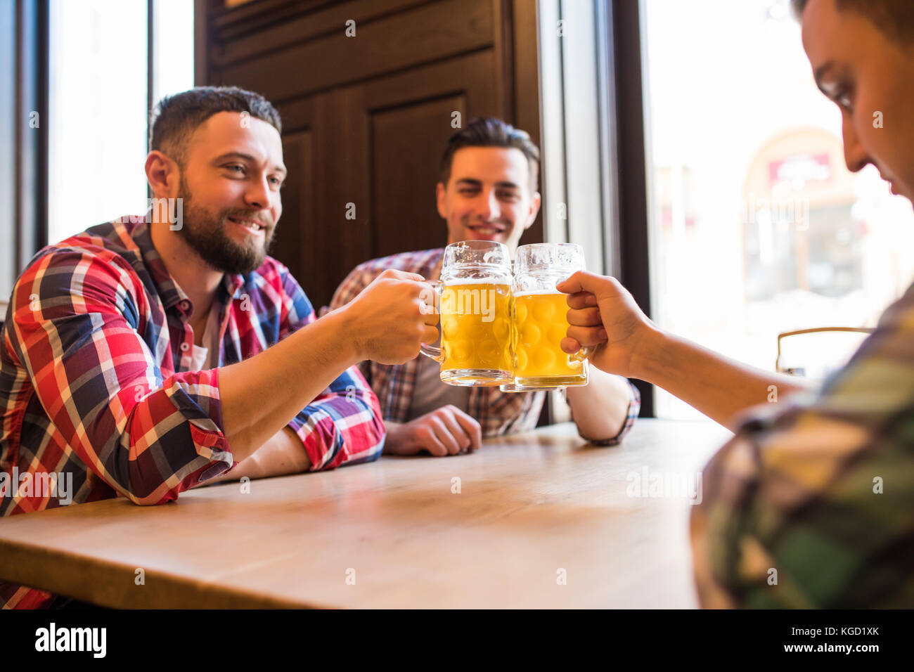 Les gens, les hommes, les loisirs, l'amitié et de fête concept - heureux amis boire une bière et clinking glasses au bar ou au pub Banque D'Images