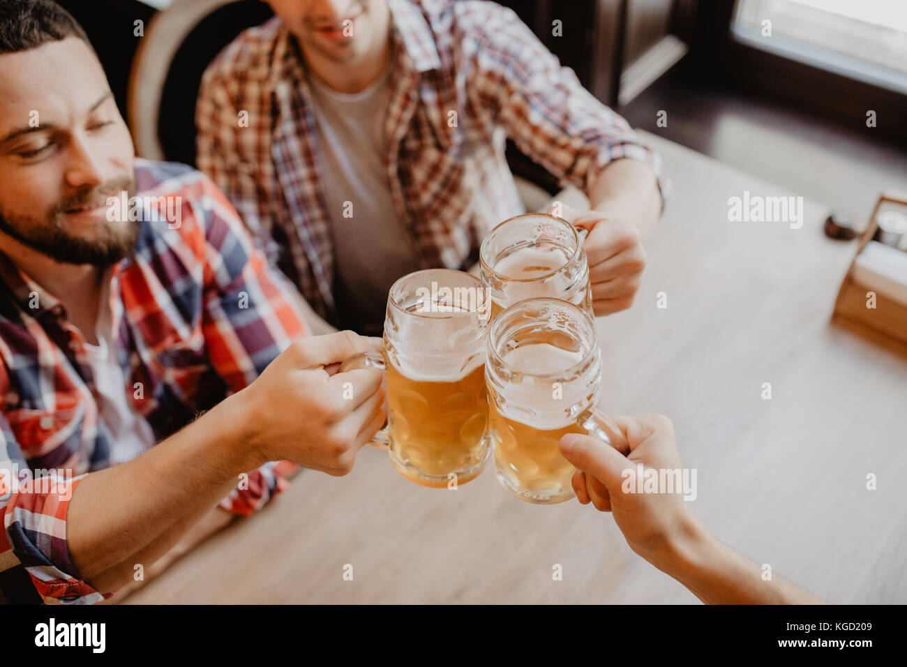 Les gens, les hommes, les loisirs, l'amitié et de fête concept - heureux amis boire une bière et clinking glasses au bar ou au pub Banque D'Images