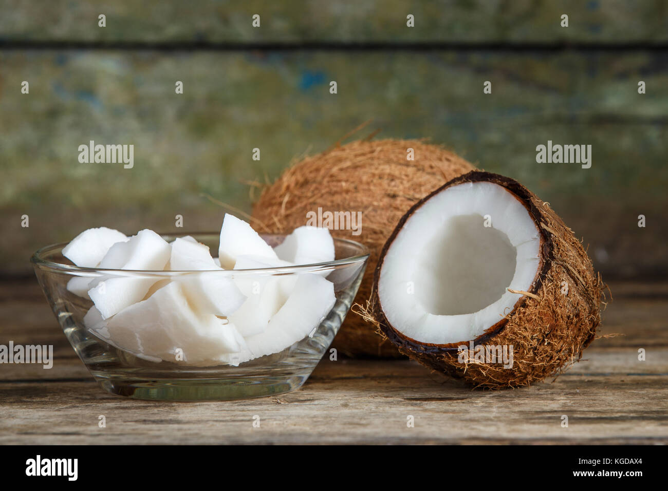 Tout frais et les couper en deux morceaux de noix de coco Coco sur fond de bois with copy space Banque D'Images