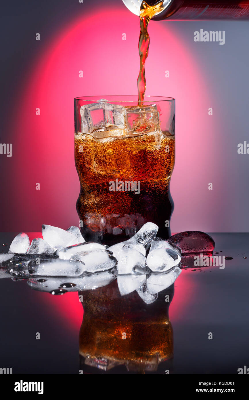 Cola en verre avec de la glace mousseux doux boisson gazeuse fast food avec grande publicité de calories avec le feu rouge arrière-plan et vignet Banque D'Images