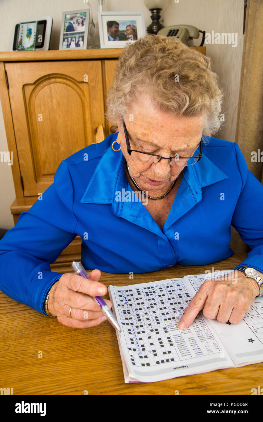Vieille Femme puzzles à table Banque D'Images