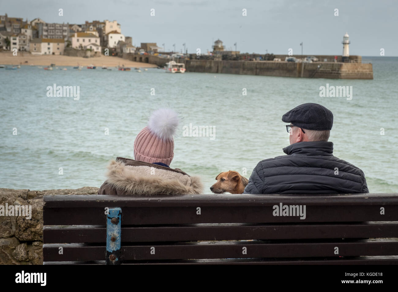 Un couple et leur chien profiter du soleil avec St Ive's Harbour Beach dans l'arrière-plan, St Ives, Cornwall, UK Banque D'Images