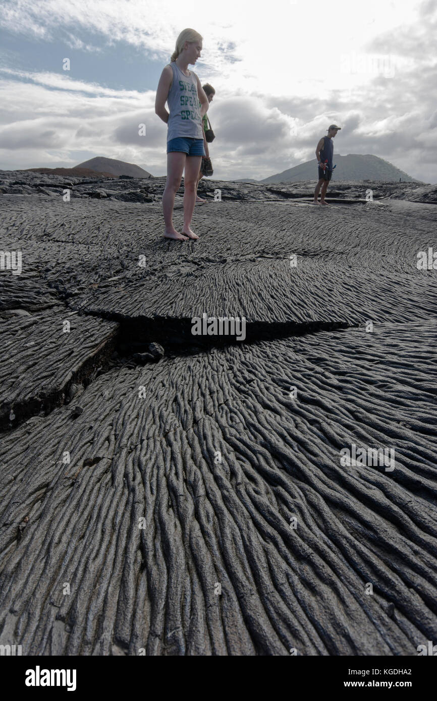 Un groupe de touristes visitent une coulée de lave récente dans les îles Galapagos. Banque D'Images