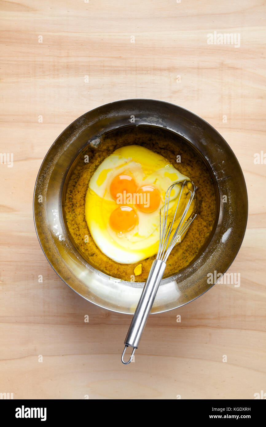 Les œufs et fouetter dans un grand bol en métal. la cuisson de la pâte à tarte ou muffins Banque D'Images