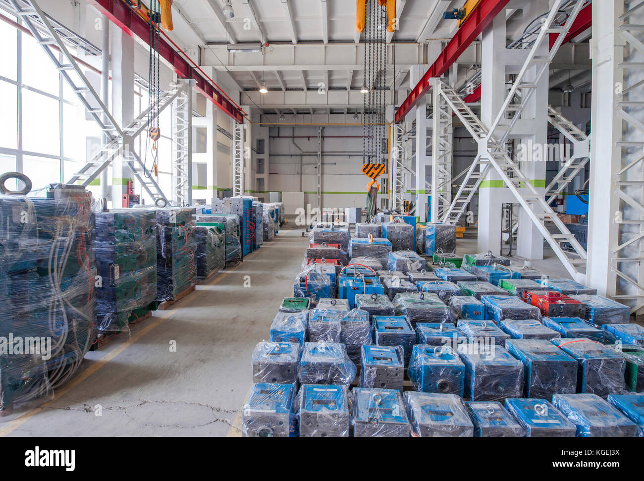 Stockage entrepôt moules machines emballées en polyéthylène et grue de levage Banque D'Images