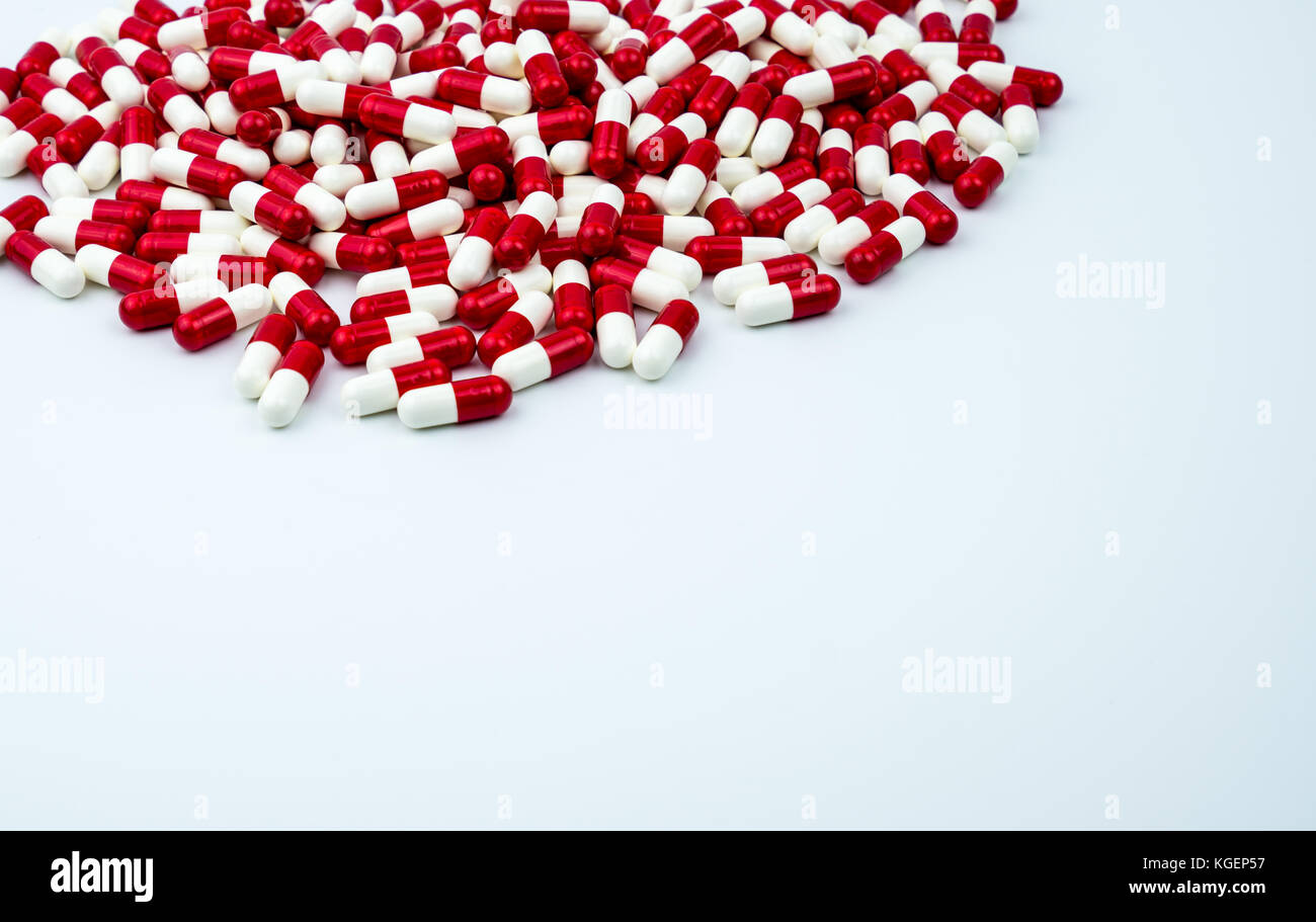Rouge, blanc capsules antibiotiques comprimés sur fond blanc avec copie espace. La résistance aux médicaments, l'utilisation d'antibiotiques avec raisonnable, les politiques de la santé et guérir Banque D'Images