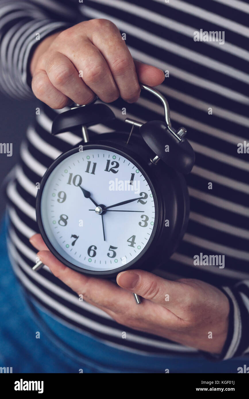 Le temps passe, femme hand holding vintage noir élégant réveil, selective focus Banque D'Images