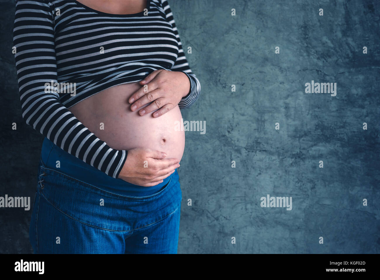 L'amour doux femelle enceinte avec les mains sur son ventre dans le troisième trimestre de la grossesse s'attendant bébé nouveau-né Banque D'Images